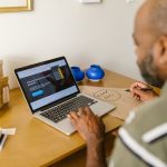 Empreendedor utiliza um laptop à mesa enquanto realiza o planejamento de seu negócio.