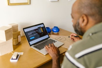 Empreendedor utiliza um laptop à mesa enquanto realiza o planejamento de seu negócio.