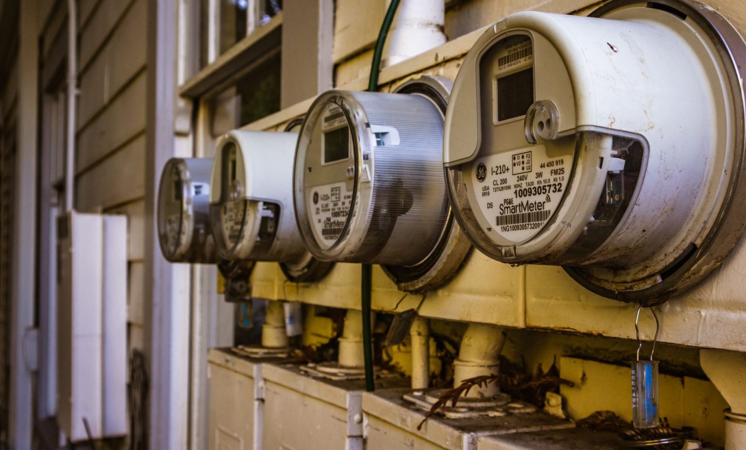 Conjunto de medidores inteligentes de energia elétrica instalados na parede externa de uma residência.