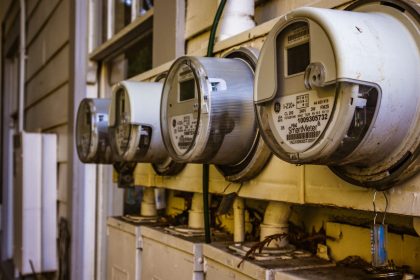 Conjunto de medidores inteligentes de energia elétrica instalados na parede externa de uma residência.